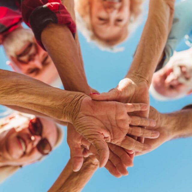 Elderly hands coming together as a team