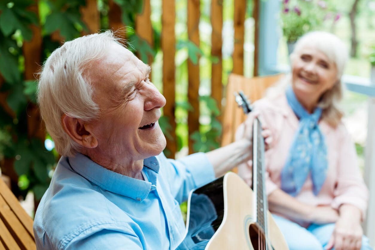 elderly couple playing guitar